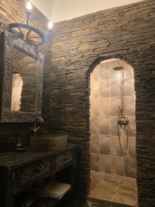 a stone bathroom with a sink and a shower at SUPERB - Medieval apartment in Kutná Hora