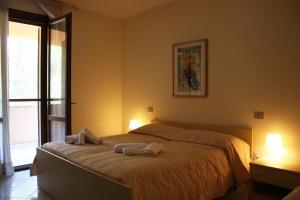 1 dormitorio con 1 cama con 2 toallas en Hotel La Pineta, en Arborea 