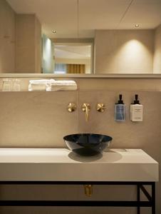 a bathroom with a black bowl sink on a counter at WIDE Hotel in Copenhagen