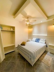 a bedroom with a bed and a ceiling fan at CASA PRAIA DA PINHEIRA in Palhoça