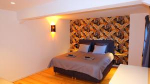 een slaapkamer met een bed in een kamer met een muur bij La Tanière des Loups in Herbeumont