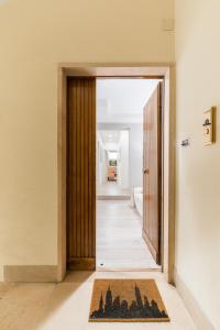 eine Tür, die in einen Flur mit einem Teppich führt in der Unterkunft Vatican Townhouse in Rom