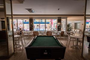 a pool table in a room with tables and chairs at Hotel Festa Brava by ALEGRIA in Lloret de Mar