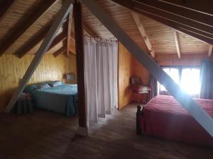 a attic bedroom with two beds and a window at Duplex El Duende in Olavarría