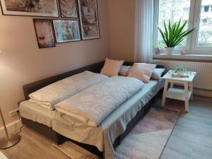 ein Bett in einem Zimmer mit einem Tisch darauf in der Unterkunft Helles modern eingerichtetes Apartment in Halle an der Saale