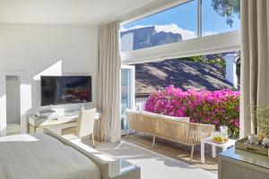 Kaap Mooi Luxury Guest House في كيب تاون: غرفة نوم بسرير ونافذة كبيرة