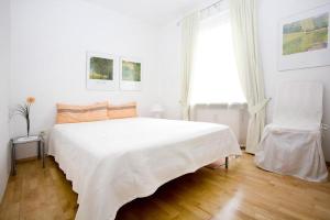 ein weißes Schlafzimmer mit einem großen Bett und einem Fenster in der Unterkunft Ferienwohnung Bregenz 6 top 3 in Bregenz