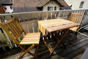 einen Holztisch und zwei Stühle auf einer Terrasse in der Unterkunft Ferienwohnung Bregenz 6 top 3 in Bregenz