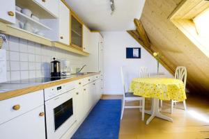 a kitchen with white cabinets and a table with a yellow table cloth at Ferienwohnung Bregenz 8 top 4 in Bregenz