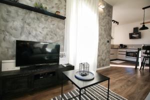 ein Wohnzimmer mit einem TV und einem Tisch in der Unterkunft Apartment Margita in Rovinj