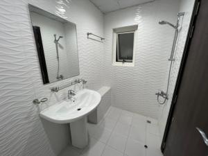 a white bathroom with a sink and a shower at Economic rooms for rent in Dubai in Dubai