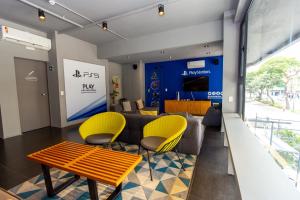a living room with a couch and yellow chairs at Hotel Centro 433 in Sao Paulo