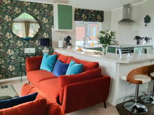 a living room with a red couch and blue pillows at Willow Lodge Auchterarder in Auchterarder