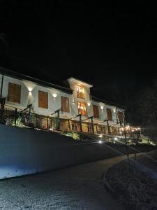 a large white house at night with lights at Illaberek Turistaház in Sukoró