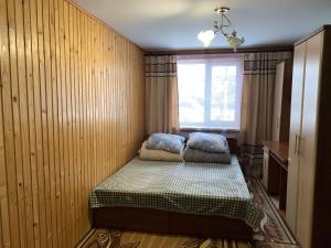 um pequeno quarto com uma cama e uma janela em Подина em Vorokhta
