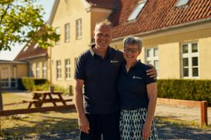 a man and woman standing in front of a house at Danhostel Ringsted in Ringsted