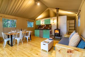uma sala de estar com uma mesa de jantar e um fogão em AfriCamps at Ingwe em Plettenberg Bay