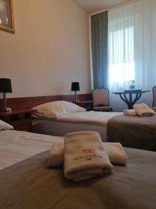a hotel room with two beds with towels on them at Ośrodek Rehabilitacyjno-Wczasowy Magnolia in Kołobrzeg