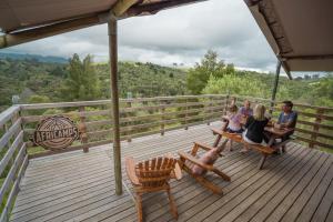 a group of people sitting on a bench on a deck at AfriCamps at Ingwe in Plettenberg Bay
