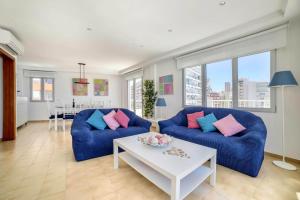 una sala de estar con 2 sofás azules y una mesa. en Apartamento Capri - PlusHolidays en Calpe