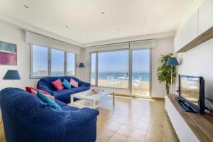 a living room with a blue couch and a tv at Apartamento Capri - PlusHolidays in Calpe