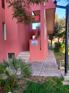 La Perla di Alghero في ألغيرو: مبنى وردي امامه درج