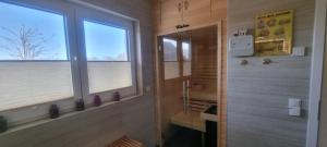 ein Bad mit einem Fenster und einer ebenerdigen Dusche in der Unterkunft Haus Kliffblick in Glowe