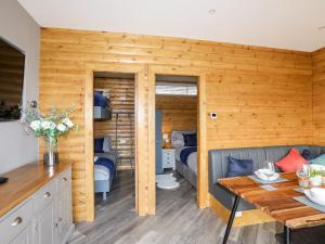 un soggiorno con un letto e un tavolo di Hilltop Lodge a Corwen
