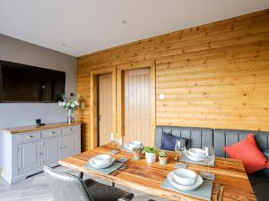 una sala da pranzo con tavolo e sedie in legno di Hilltop Lodge a Corwen Altre 25 foto