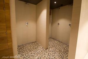 a bathroom with two shower stalls and a tiled floor at Hotel Bero in Ostend