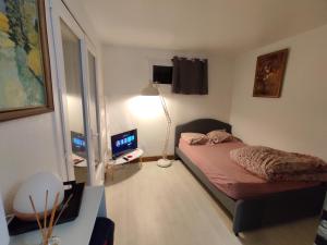 a bedroom with a bed and a desk with a computer at Studio Marjorie Indep. dans maison particulière in Mérignac