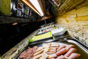 un buffet con salchichas y otros alimentos en un mostrador en Pensjonat Fitness & Spa Gregor, en Zielona Góra 64 fotos más