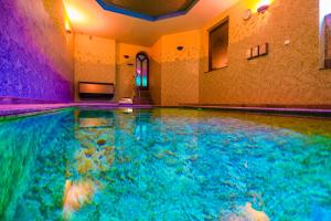 una piscina cubierta con agua azul en una habitación en Pensjonat Fitness & Spa Gregor, en Zielona Góra