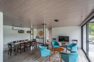 ein Wohnzimmer mit blauen Stühlen und ein Esszimmer in der Unterkunft Casa en Potrerillo de Larreta in Alta Gracia