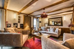 a living room with couches and a table at Les Monts Charvin in Courchevel