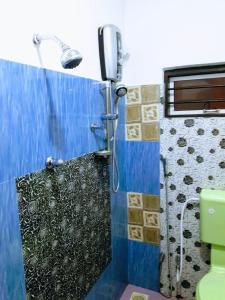 y baño con ducha y pared azul. en Koslanda Rest, en Koslanda