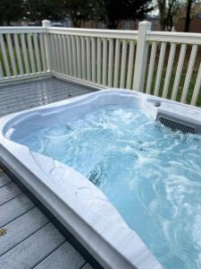 a hot tub on a deck with a fence at Dakota Lodge with Hot Tub in York