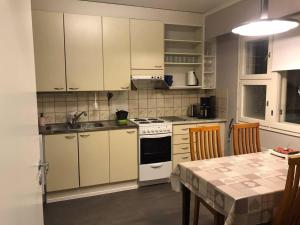 a kitchen with white cabinets and a table with a tablecloth on it at Villa Vankka in Pohjaslahti