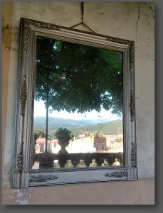 a window in a wall with a view of a tree at La Belle dAme in Prades
