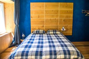 1 dormitorio con 1 cama con pared azul en Domaine de Malpas, en Villers-le-Lac