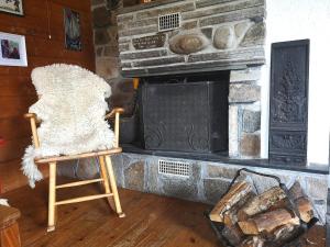 a rocking chair in front of a stone fireplace at Lysebakken, koselig feriehytte på Vestland in Reed