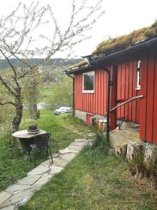 a red house with a bench in front of it at Lysebakken, koselig feriehytte på Vestland in Reed