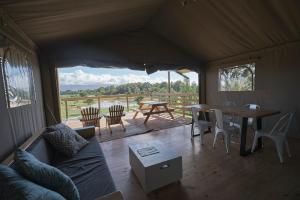 a living room with a couch and a table and chairs at AfriCamps at Kam'Bati in Swellendam