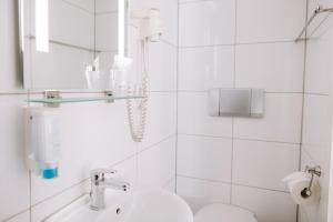 Boutique Hotel Villa Oberkassel في دوسلدورف: حمام أبيض مع حوض ومرحاض