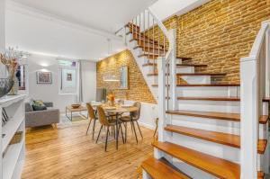 a dining room and living room with a brick wall at LE BROADWAY - Duplex entièrement rénové in Toulouse