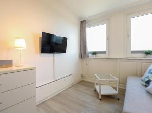 sala de estar con TV en la pared en Appartement Kaya, en Westerland