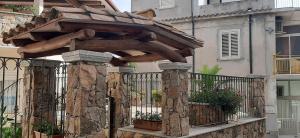a wooden structure on a fence next to a building at Il pergolato in Bari Sardo +9 photos