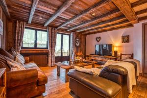 a living room with a couch and a tv at Le Coeur de Courchevel in Courchevel