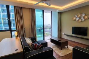 a living room with chairs and a table and a television at Lovely Vivacity Jazz Suite 2 Cozy Condo 2 Card LV6 in Kuching
