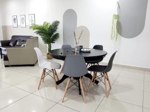 a dining room with a black table and chairs at Residensi Flora in Seri Kembangan